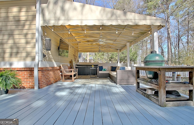 wooden deck featuring a ceiling fan, a grill, and an outdoor hangout area