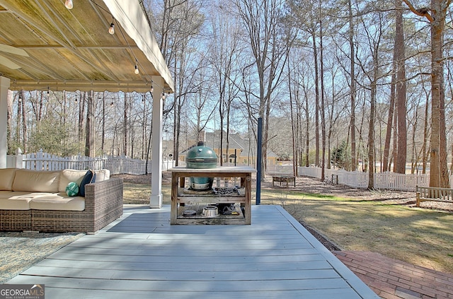 deck with an outdoor hangout area, area for grilling, and a fenced backyard