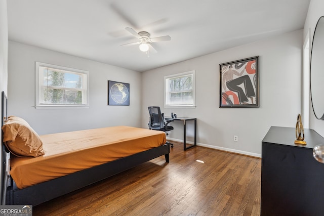 bedroom with ceiling fan, baseboards, and wood finished floors