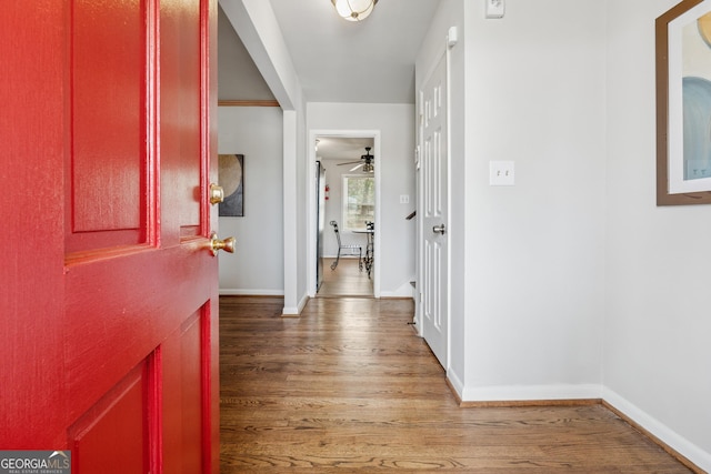 hall with baseboards and wood finished floors