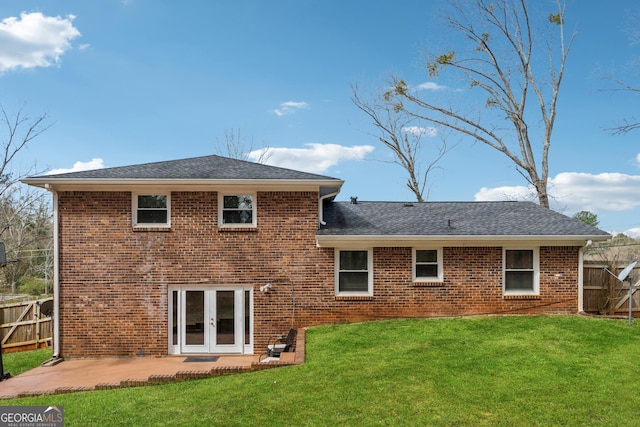 back of house with brick siding, fence, a lawn, french doors, and a patio area