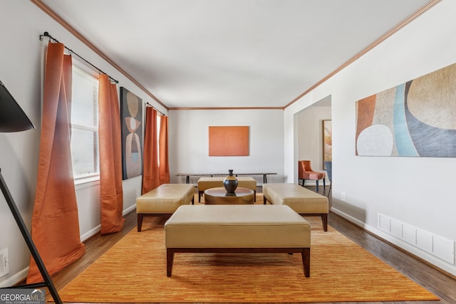 sitting room with baseboards, visible vents, light wood-type flooring, and ornamental molding