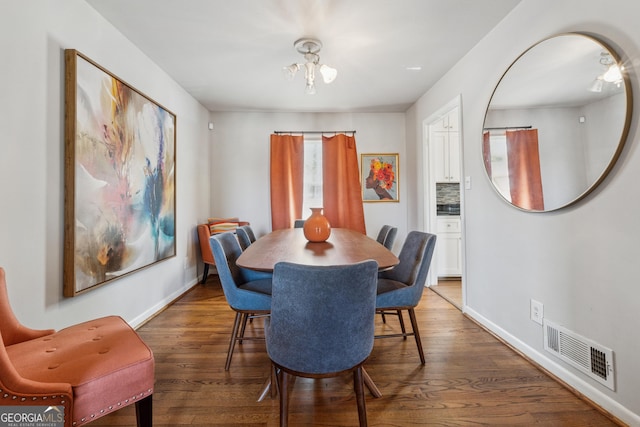 dining space with visible vents, baseboards, and wood finished floors