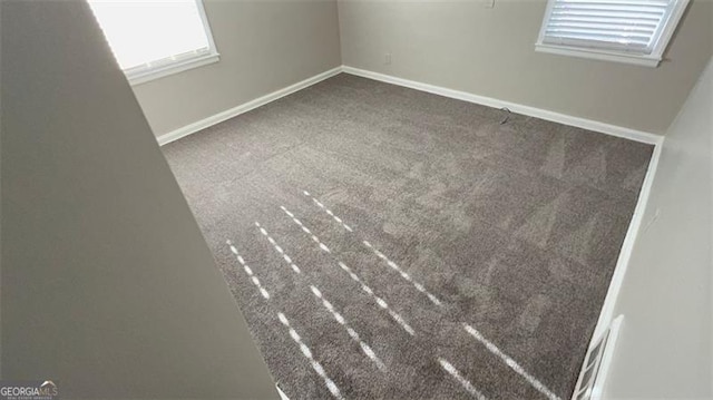 spare room featuring carpet flooring and baseboards