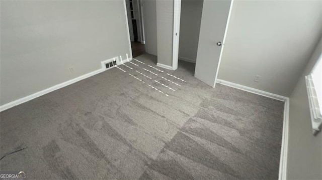 unfurnished bedroom with carpet floors, visible vents, and baseboards