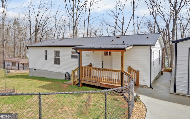 view of front of house featuring a front yard, crawl space, metal roof, fence private yard, and a wooden deck