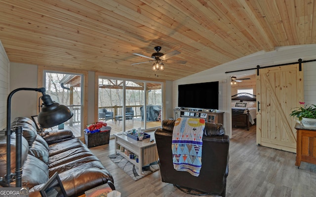 living room with wood ceiling, a barn door, vaulted ceiling, and wood finished floors