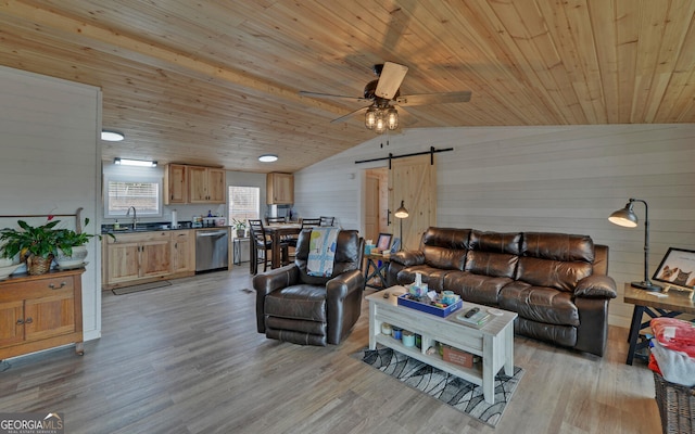 living area with wood ceiling, light wood finished floors, a barn door, and vaulted ceiling