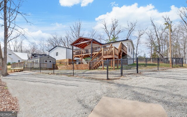 view of front of property with a deck, stairs, fence private yard, and a gate