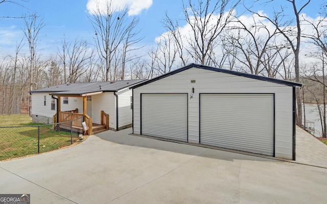 view of front of property featuring a garage, fence, and metal roof