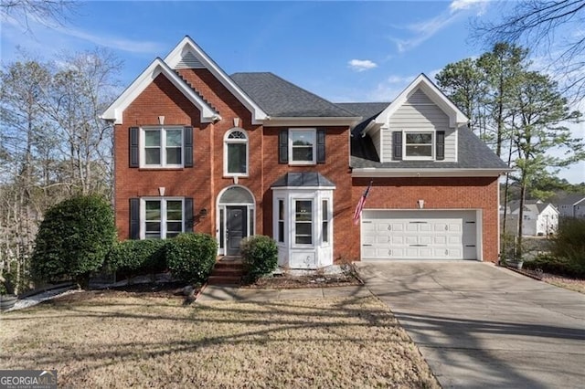 colonial inspired home with driveway, roof with shingles, a garage, and brick siding