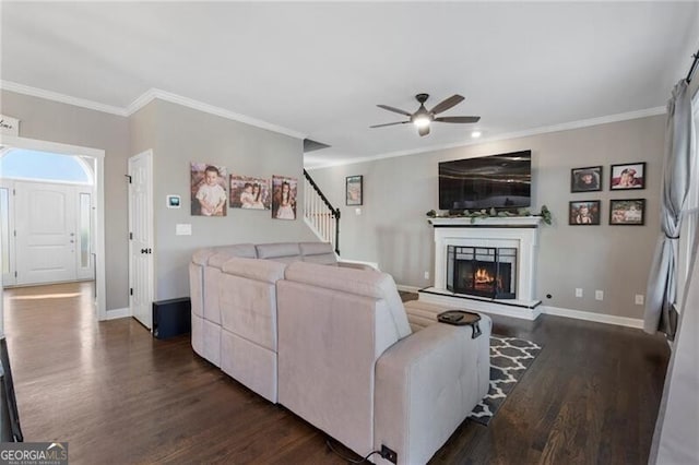 living area featuring ornamental molding, dark wood finished floors, and baseboards