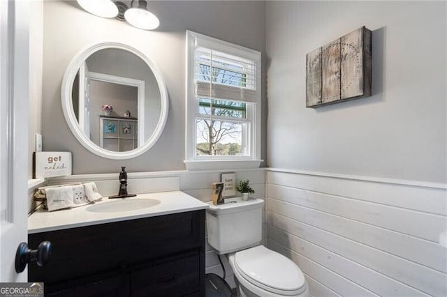 bathroom with wainscoting, vanity, and toilet