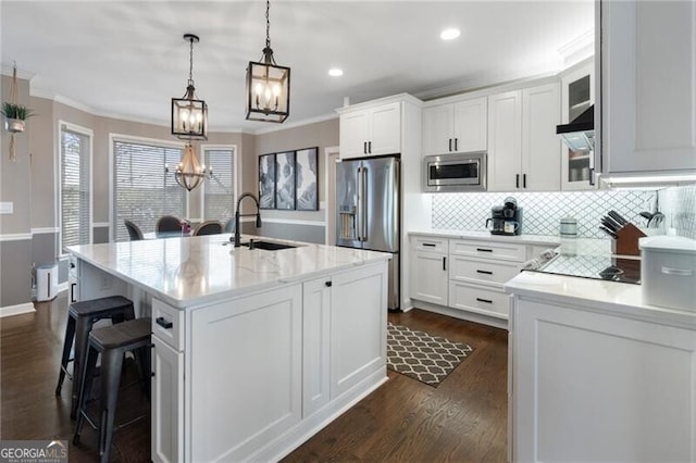 kitchen with stainless steel appliances, white cabinets, a sink, and ornamental molding