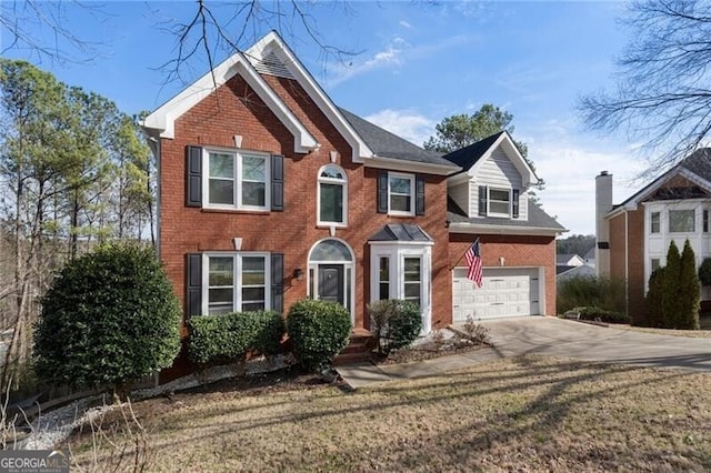 colonial-style house featuring driveway, an attached garage, and brick siding