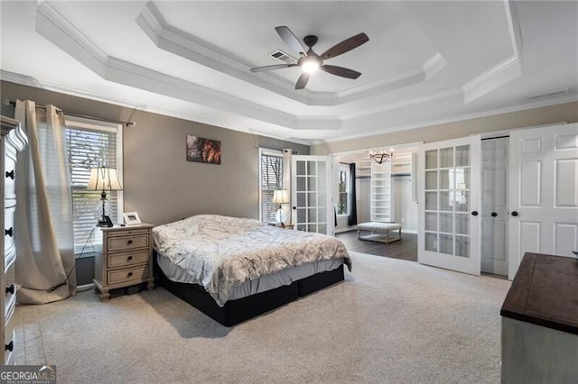 carpeted bedroom featuring visible vents, a raised ceiling, ceiling fan, crown molding, and french doors