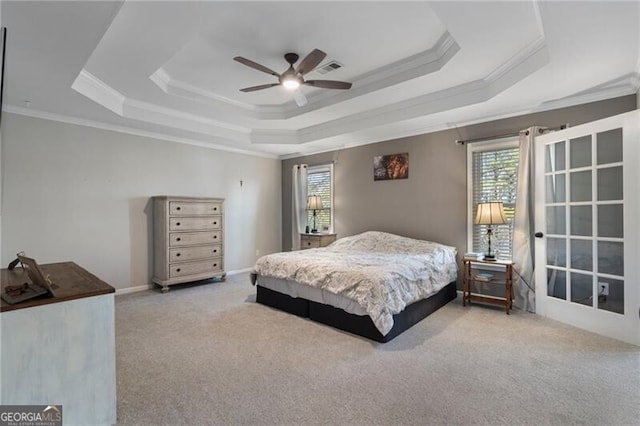 bedroom with baseboards, a tray ceiling, crown molding, and light colored carpet