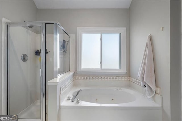 bathroom featuring a stall shower and a tub with jets