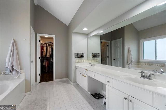 full bathroom with a bath, double vanity, vaulted ceiling, and a sink