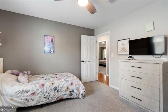 bedroom featuring baseboards, a ceiling fan, and light colored carpet