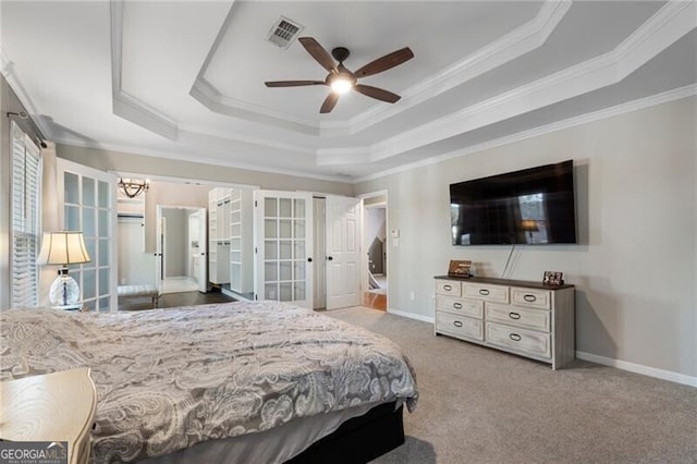 carpeted bedroom featuring ornamental molding, a tray ceiling, visible vents, and baseboards