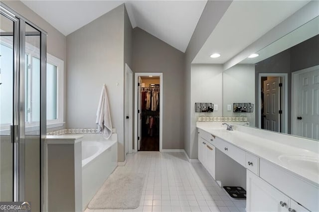 full bathroom featuring vaulted ceiling, a shower stall, a bath, tile patterned floors, and double vanity