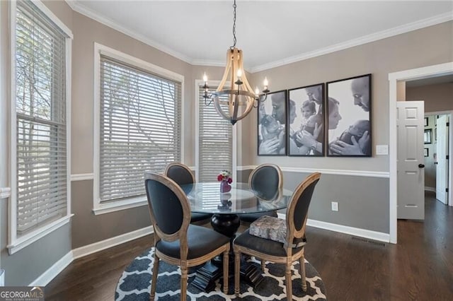 dining area featuring baseboards, a chandelier, wood finished floors, and crown molding