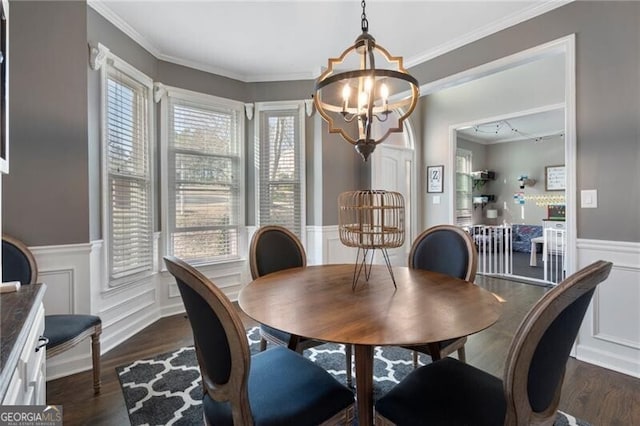 dining room featuring a notable chandelier, ornamental molding, dark wood-type flooring, and wainscoting