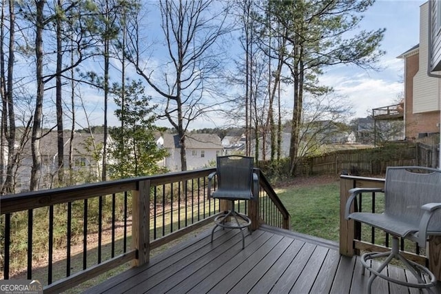 wooden deck with a lawn and fence