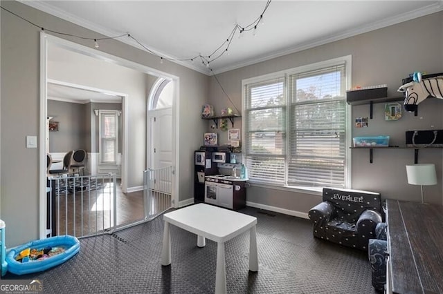 game room with baseboards and crown molding