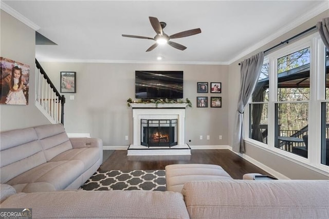 living room featuring baseboards, crown molding, and wood finished floors