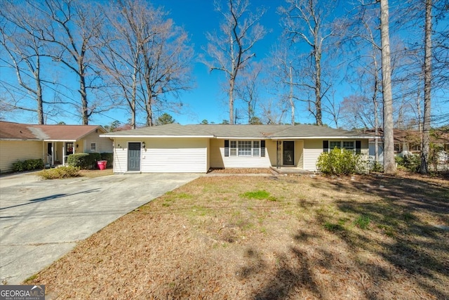 ranch-style house with concrete driveway and a front lawn