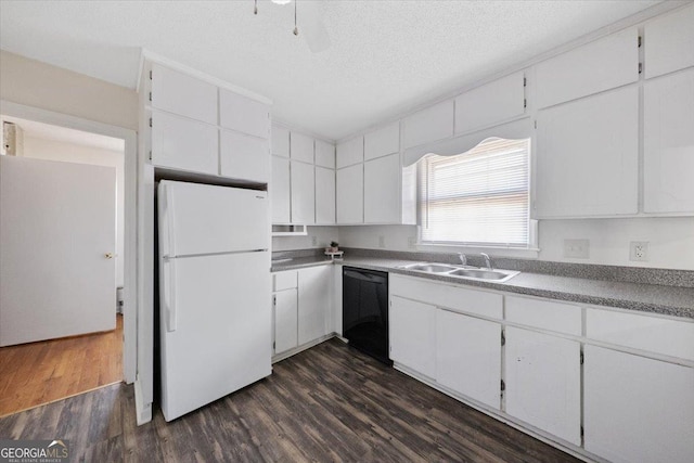 kitchen with black dishwasher, white cabinets, dark wood-type flooring, freestanding refrigerator, and a sink