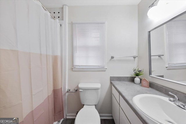 bathroom with toilet, a shower with shower curtain, and vanity