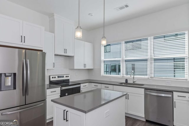 kitchen with dark countertops, visible vents, stainless steel appliances, and a sink