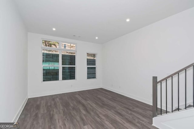 empty room featuring stairway, recessed lighting, wood finished floors, and baseboards