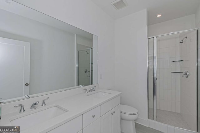 bathroom with toilet, a stall shower, a sink, and visible vents