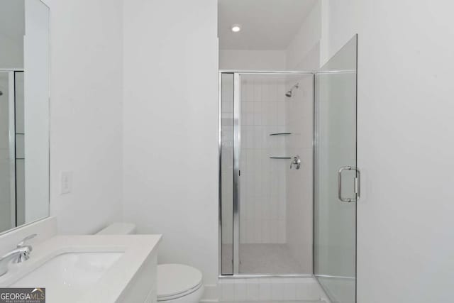 full bath with vanity, a shower stall, and toilet