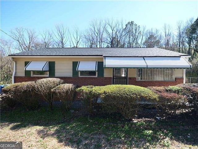 ranch-style house featuring brick siding