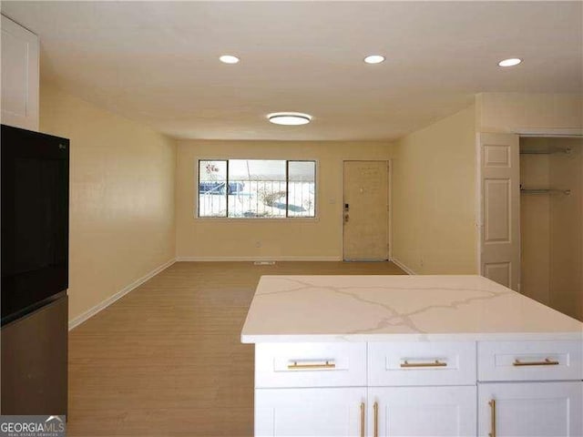 kitchen featuring light wood-style flooring, white cabinetry, baseboards, and recessed lighting