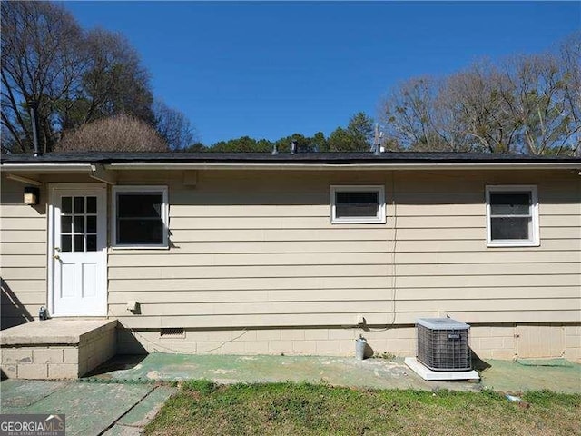 view of side of home with central AC unit and crawl space