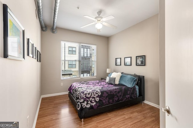 bedroom featuring ceiling fan, baseboards, and wood finished floors