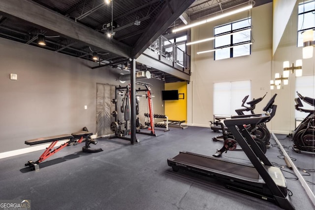 workout area with a high ceiling and baseboards