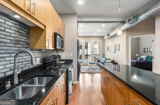 kitchen with open floor plan, a sink, stainless steel electric range, light wood-type flooring, and backsplash