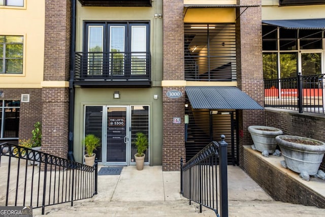 property entrance featuring brick siding and stucco siding