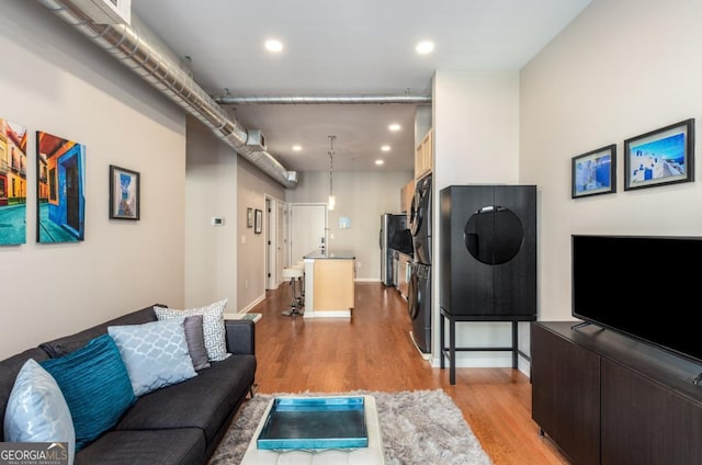 living area with light wood-style flooring, baseboards, and recessed lighting