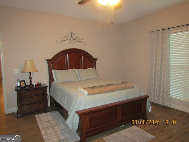 bedroom featuring ceiling fan, baseboards, and wood finished floors