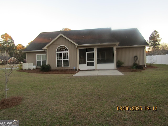 rear view of house featuring a yard, fence, and a patio