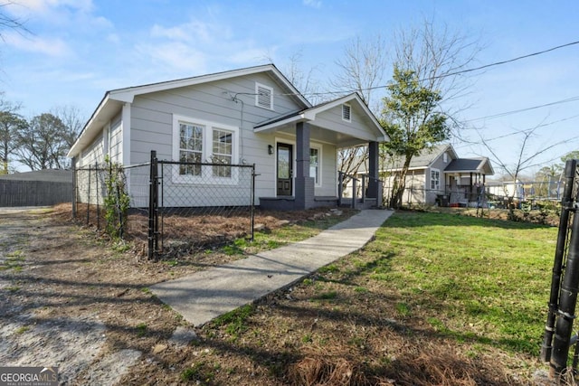 bungalow-style home featuring covered porch, fence, and a front yard