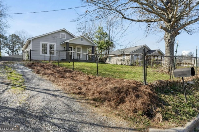 view of front of house with driveway, a fenced front yard, and a front yard